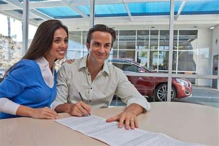 happy customers signing at dealership
