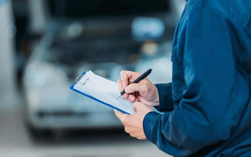mechanic writing on clip board