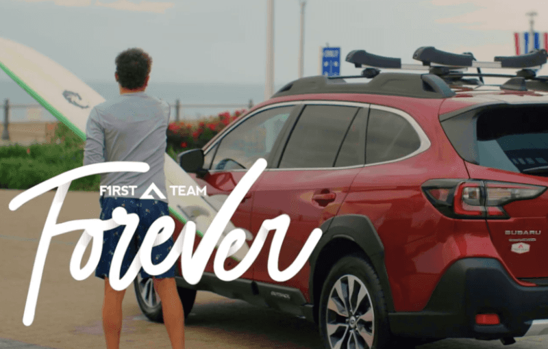 First Team Forever with man getting out of Subaru holding a surfboard