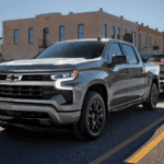 2026 Chevy Silverado 1500 towing classic car on city street