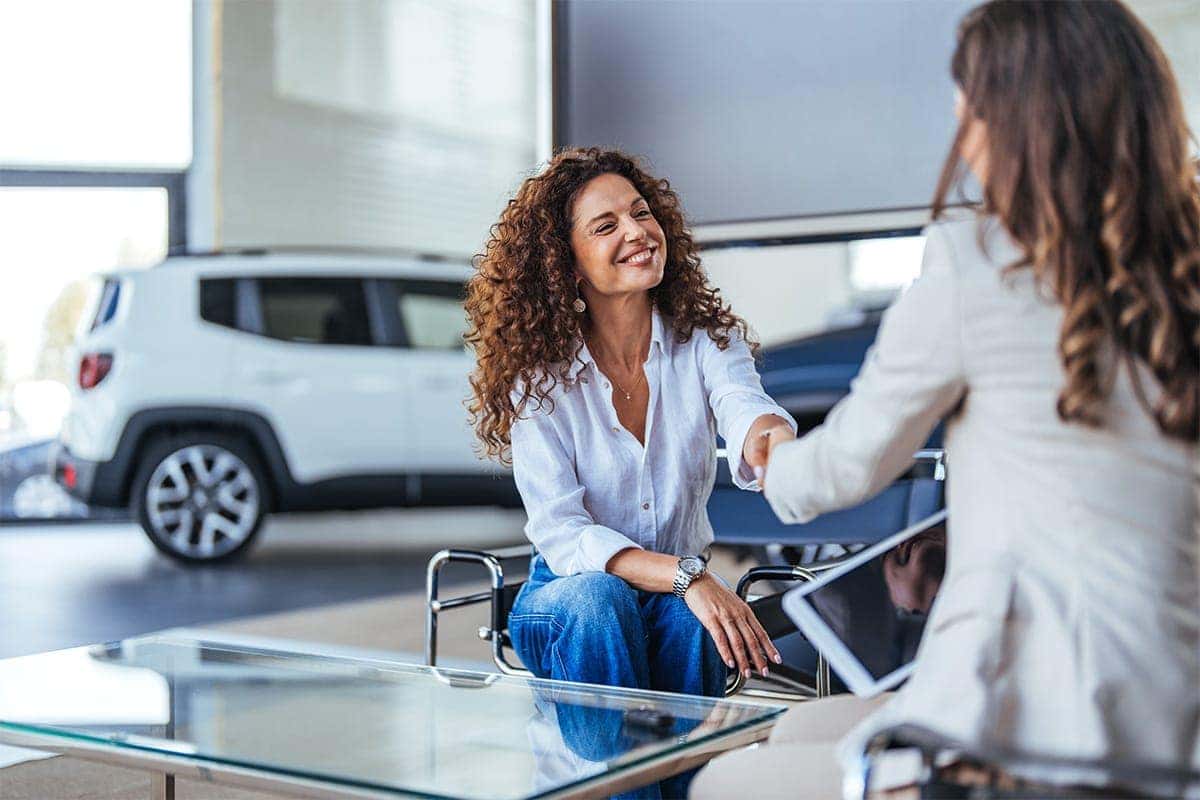 Female dealer shaking hands with a female customer