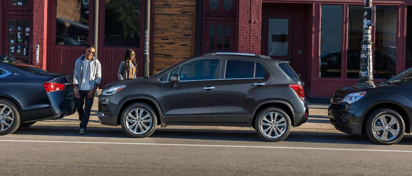 Young couple walking to Gray 2020 Chevy Trax Parked on the street