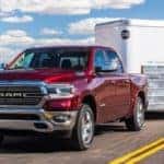 Red 2019 RAM 1500 towing trailer on desert highway