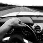 driver view of long straight road in black and white