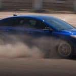 New Blue Kia Forte Racing Down Desert Road