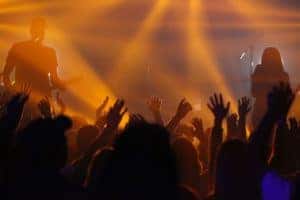 A crowd dancing to a band playing in a music venue