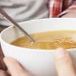 Homeless Man Being Handed Bowl Of Soup By Volunteer