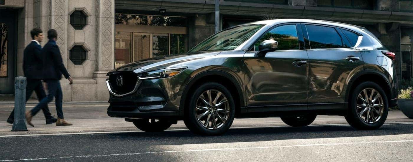 A silver 2021 Mazda CX-5 is shown parked in a city.