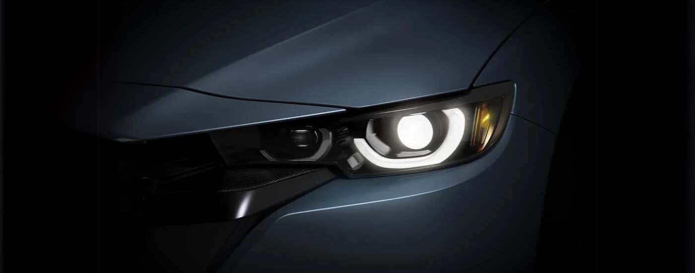 The driver side headlight is shown on a grey 2023 Mazda CX-50 for sale.