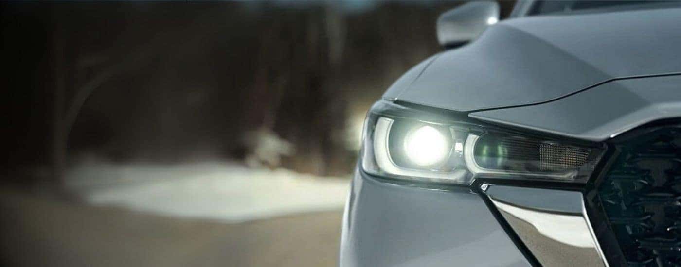 Illuminated driver side headlight on a silver 2025 Mazda CX-5 for sale near East Hartford.