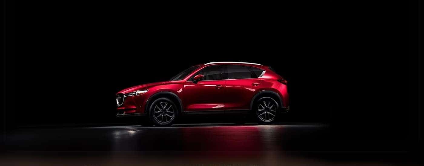 A red 2018 Mazda CX-5 in a dark warehouse.