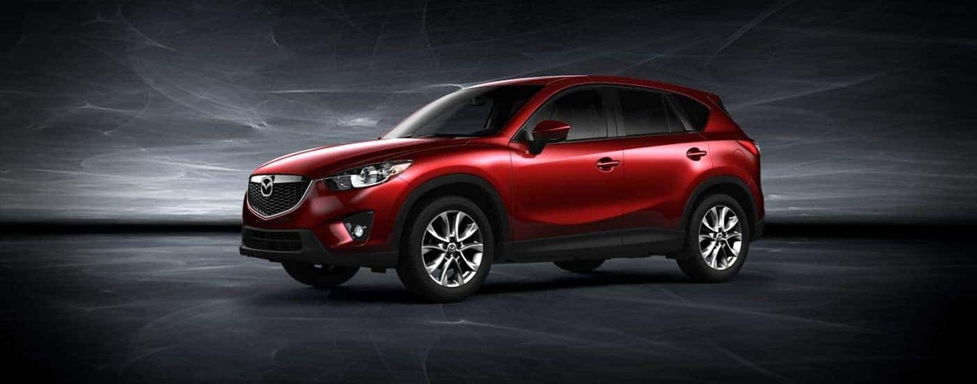A red 2015 Mazda CX-5 for sale near Willimantic against a dark background.