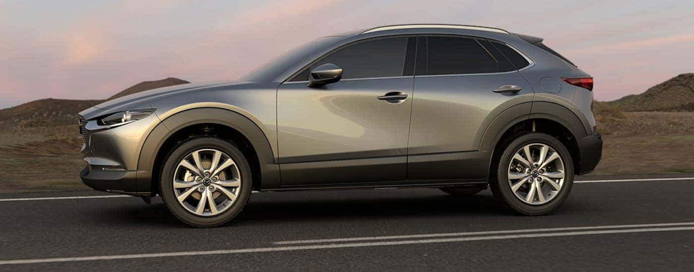 A silver 2020 Mazda CX-30 driving to view a used Mazda for sale near Hartford.