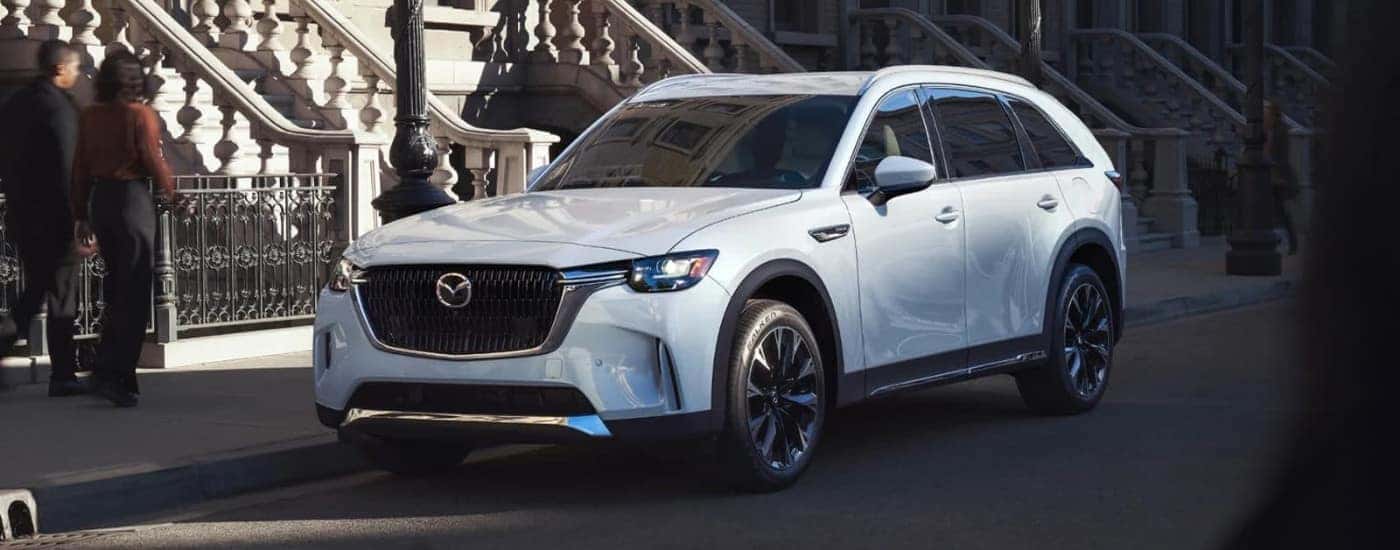 A white 2025 Mazda CX-90 PHEV parked on a city street