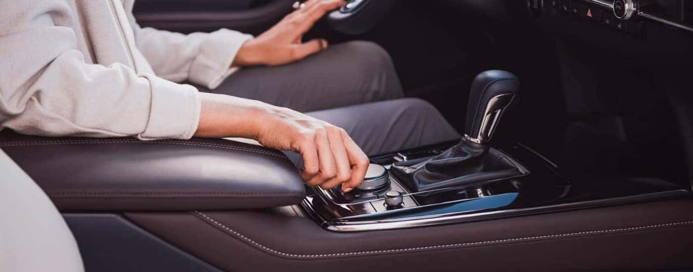 Person turning an infotainment knob in a 2022 Mazda CX-30.