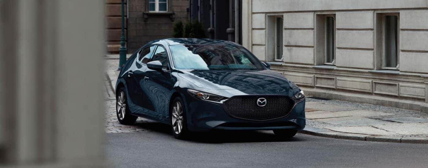A blue 2025 Mazda3 is shown driving Mazda dealer near Glastonbury.