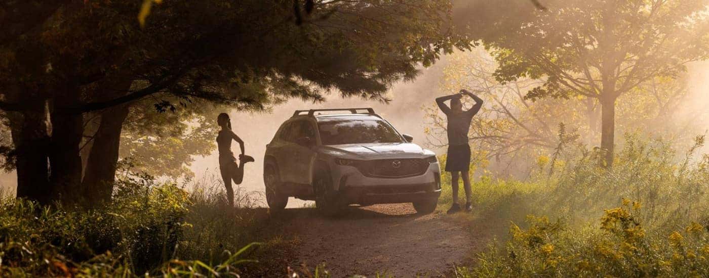 A white 2025 Mazda CX-50 Hybrid is shown on a trail.