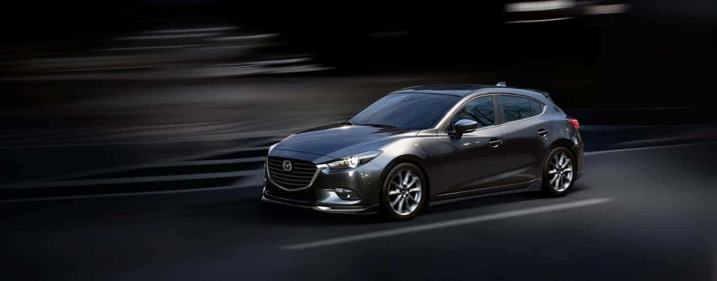 A grey 2018 used Mazda3 for sale near Coventry against a dark background.