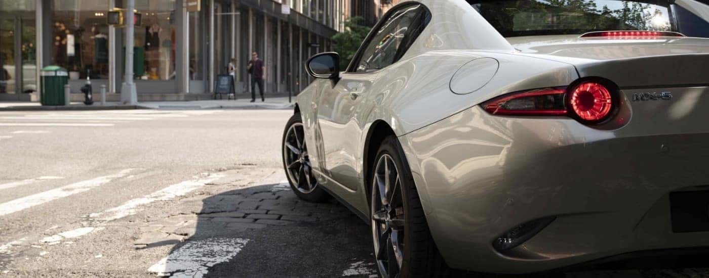 A grey 2022 Mazda MX-5 Miata on a crosswalk.