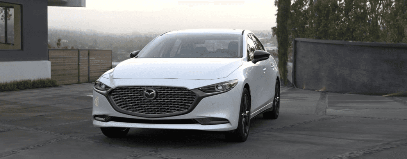 White 2026 Mazda3 parked in front of a house