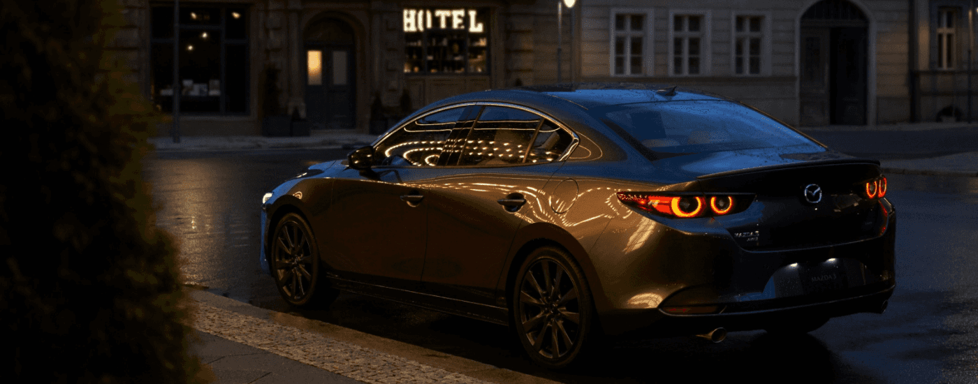 Dark grey 2026 Mazda3 from the rear parked on a street