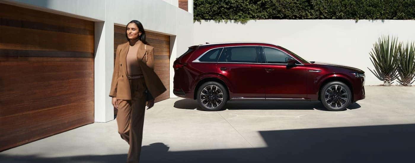 A red 2026 Mazda CX-90 parked on a driveway.