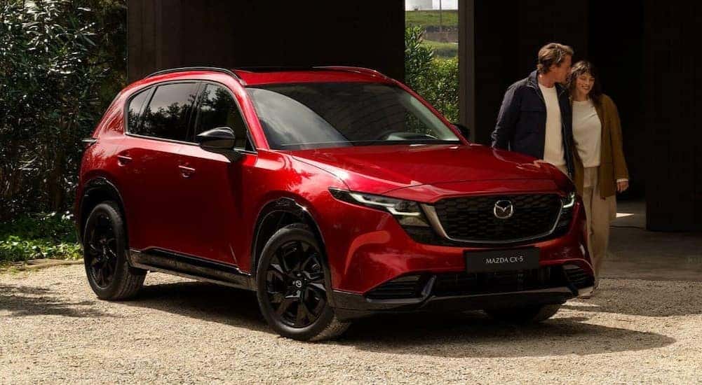 People walking near a 2026 Mazda CX-5 for sale in Manchester.