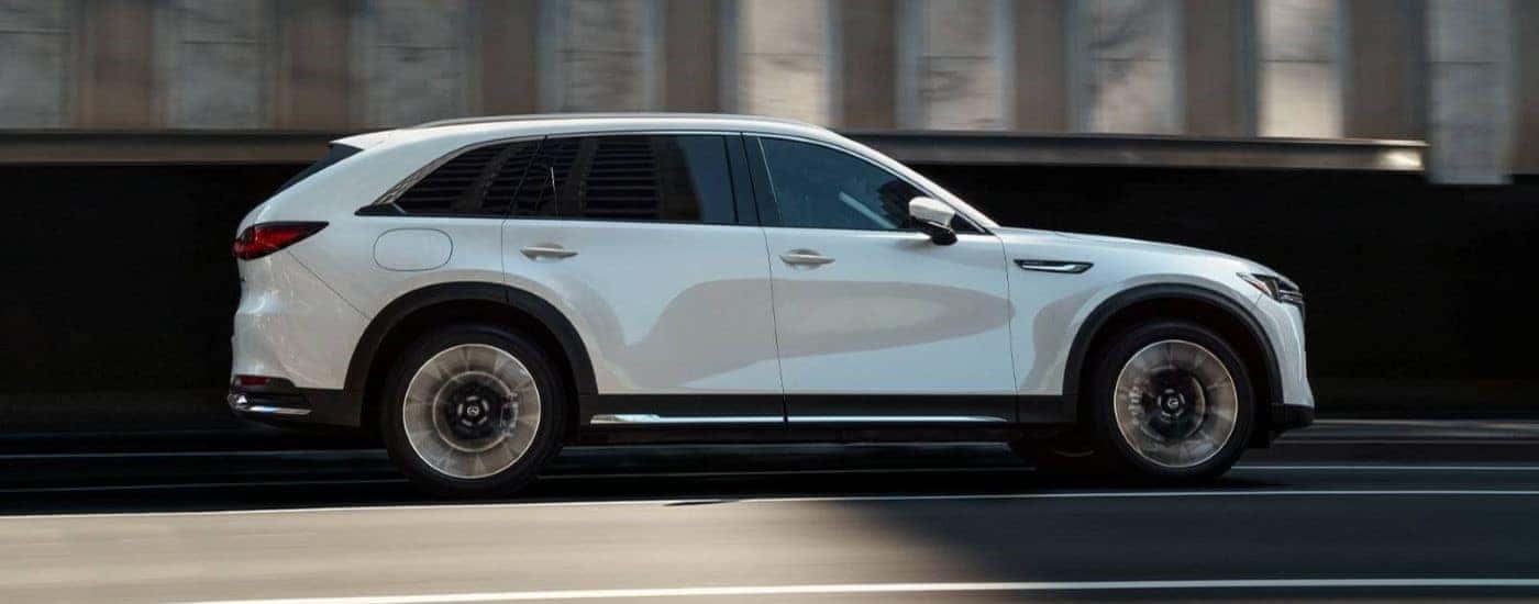 White 2024 Mazda CX-90 driving to see a used Mazda for sale near East Windsor