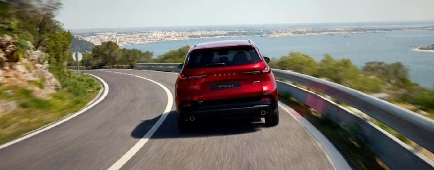 A red 2026 Mazda CX-5 driving on a highway.