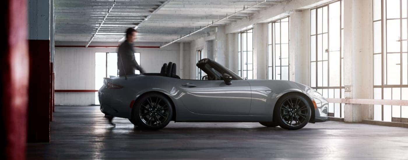 A person walking near a 2026 Mazda MX-5 Miata.