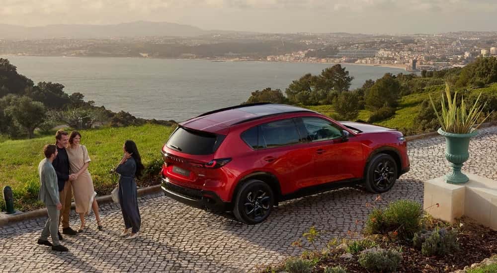 People chatting near a red 2026 Mazda CX-5