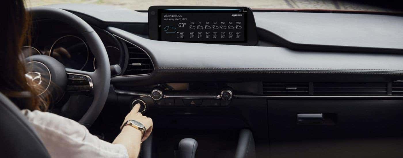 A person turning on their 2026 Mazda3 with push-start.