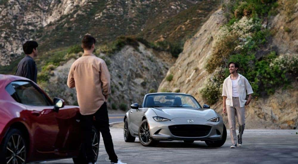 A silver and a red 2026 Mazda MX-5 Miata facing each other with friends.