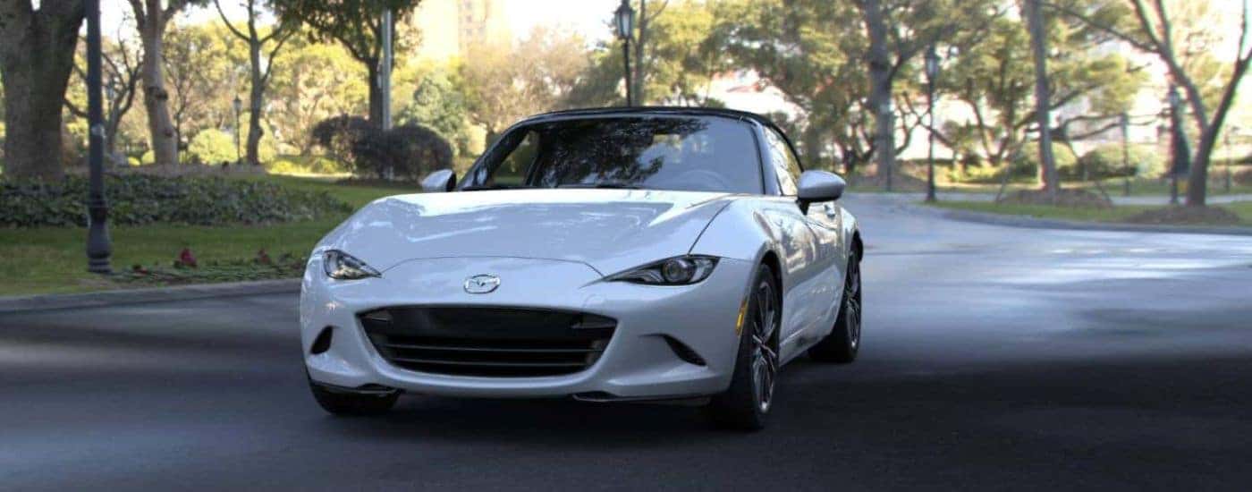 A silver 2026 Mazda MX-5 Miata shown driving a paved road.