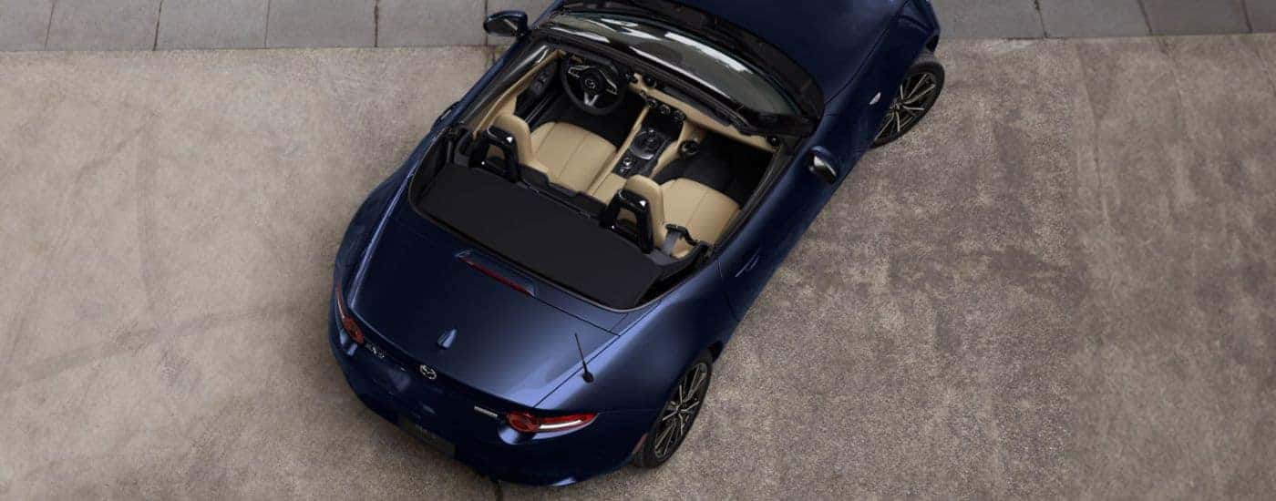 Bird's eye view of a blue Mazda MX-5 Miata with the top down.