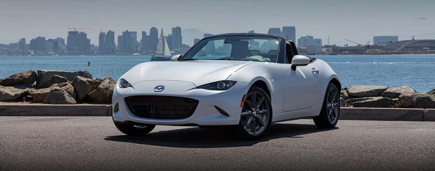 White 2023 Mazda MX-5 Miata parked near a bay