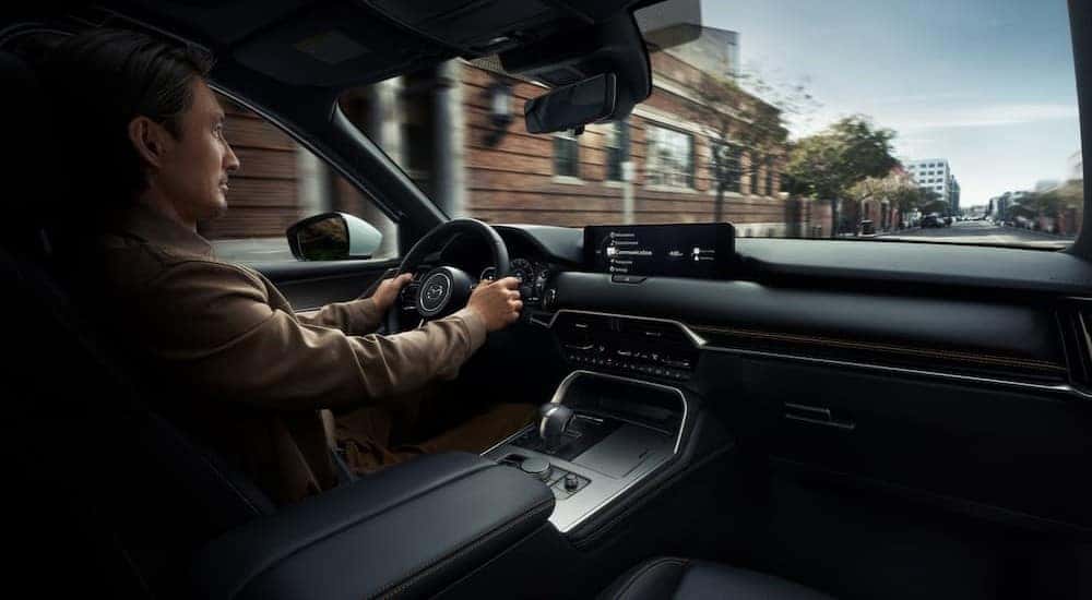 A person driving in a 2026 Mazda CX-90.