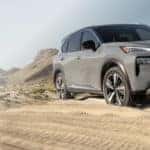 gray suv driving through a sand dune