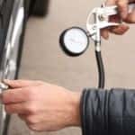 Auto mechanic checking tire pressure