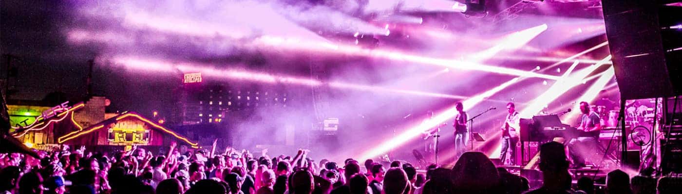Live band performing amid vibrant light show at CrossroadsKC
