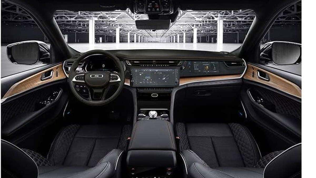 2026 Jeep Grand Cherokee interior with front seats, wood trim and dual dashboard screens