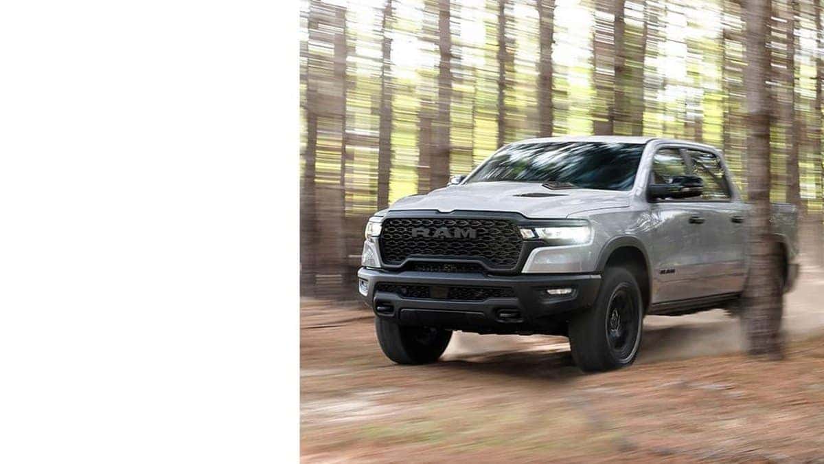 2026 Ram 1500 driving off-pavement through a wooded trail