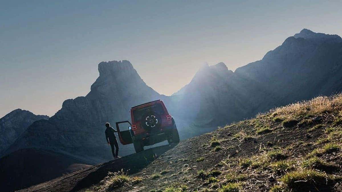 2026 Jeep Wrangler rear view on a mountain trail at sunset