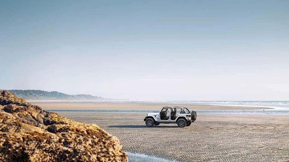 2026 Jeep Wrangler with doors removed, parked on a beach