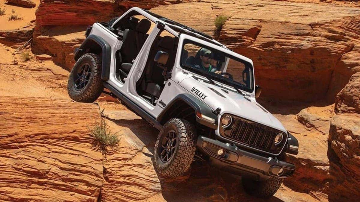 2026 Jeep Wrangler climbing a rock formation, trail-rated capability