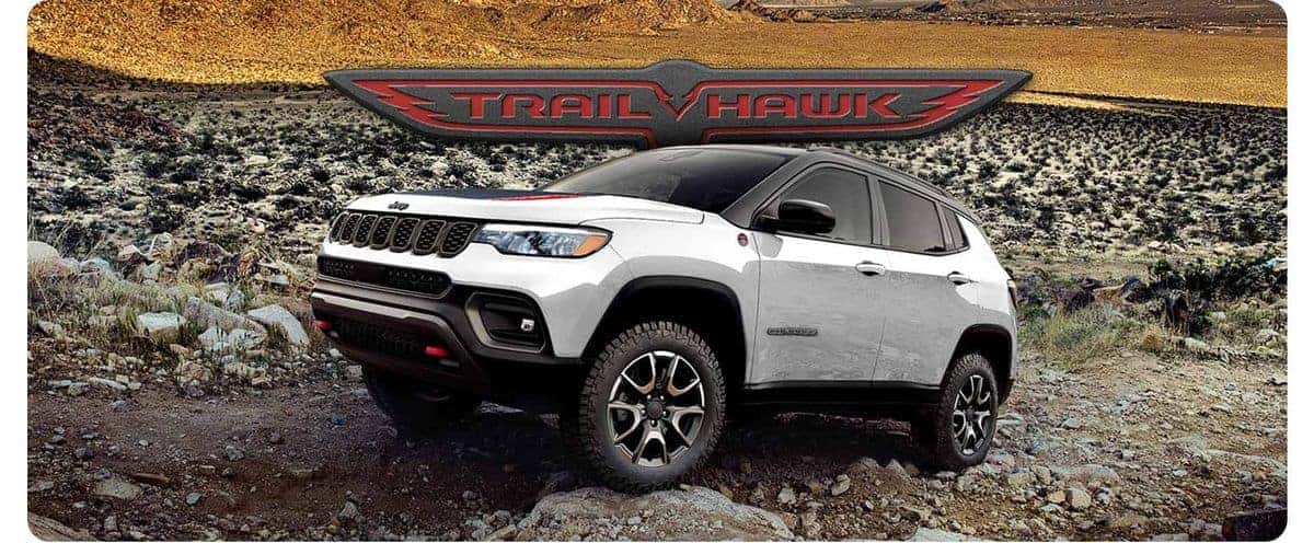 2026 Jeep Compass Trailhawk climbing a rocky desert trail with Trailhawk badge overlay