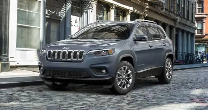 Bluish-gray 2021 Jeep Cherokee parked on a cobblestone road