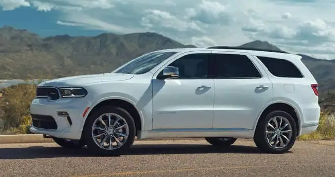 White 2021 Dodge Durango driving by mountains