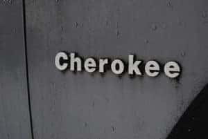 the word cherokee on a wet, grey car