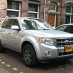 a grey ford suv parked reverse into a parking stpo